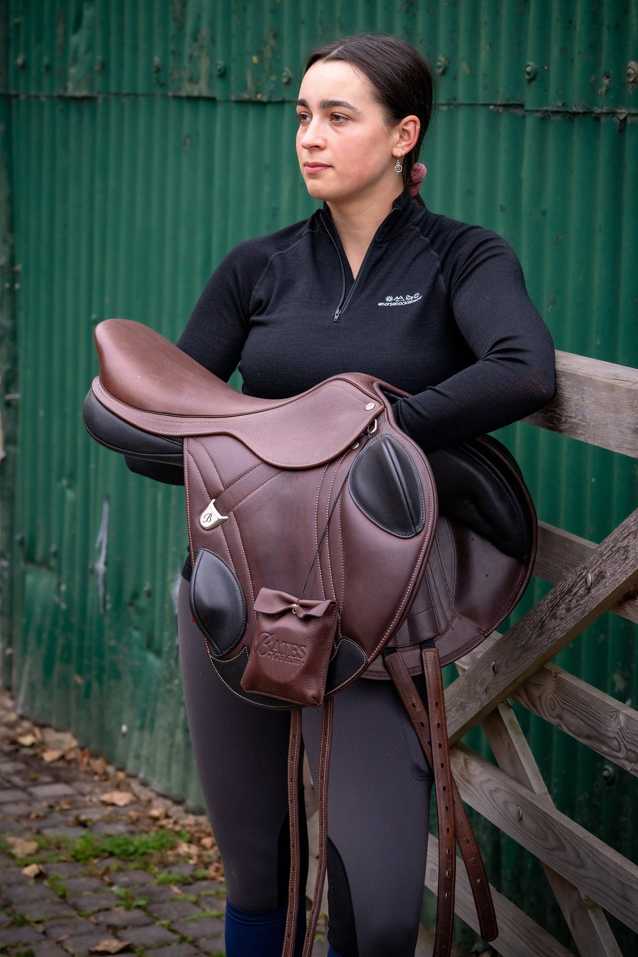 An Advanta Bates Saddle carried by a young female rider about to tack up