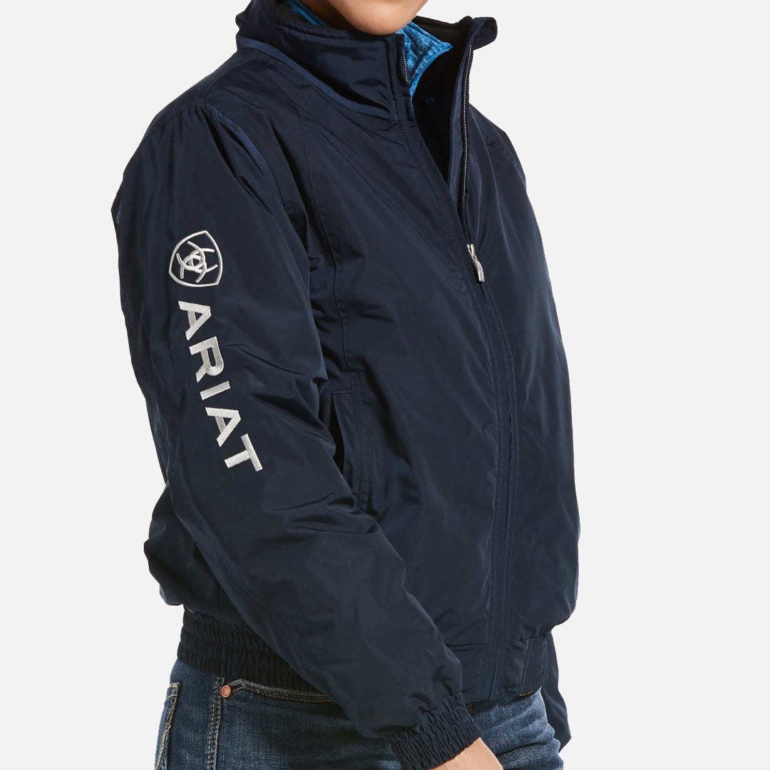 Ariat Insulated Stable Jacket model stands to the side showing zip and ariat logo detail on the arm
