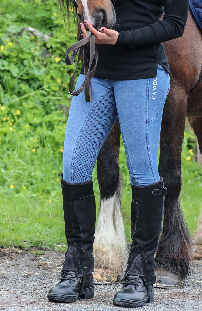 Rider stands in front of horse in the Cameo Equine denim riding tights. Image shows the sticky inner thigh/knee feature