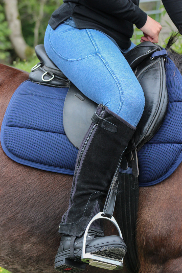 Side view of rider on horse wearing the Cameo Equine denim riding tights
