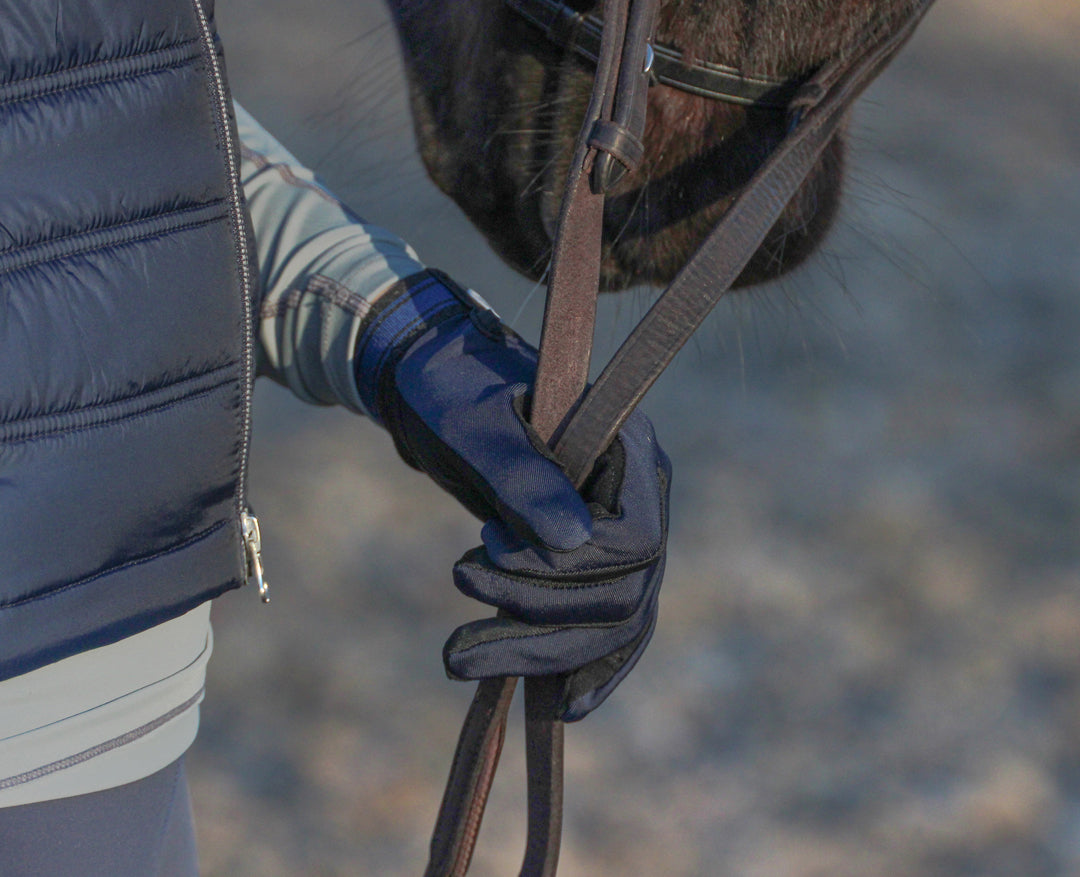 Close up of a riders hand holding reins whilst wearing the super fit riding gloves
